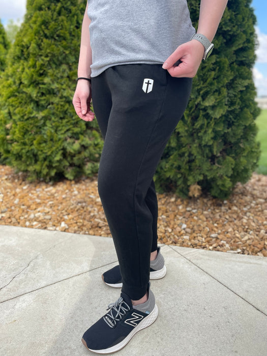 black athletic joggers with cross emblem near pocket
