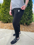 black athletic joggers with cross emblem near pocket