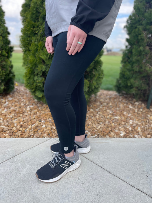 black active high rise leggings with cross emblem near ankle